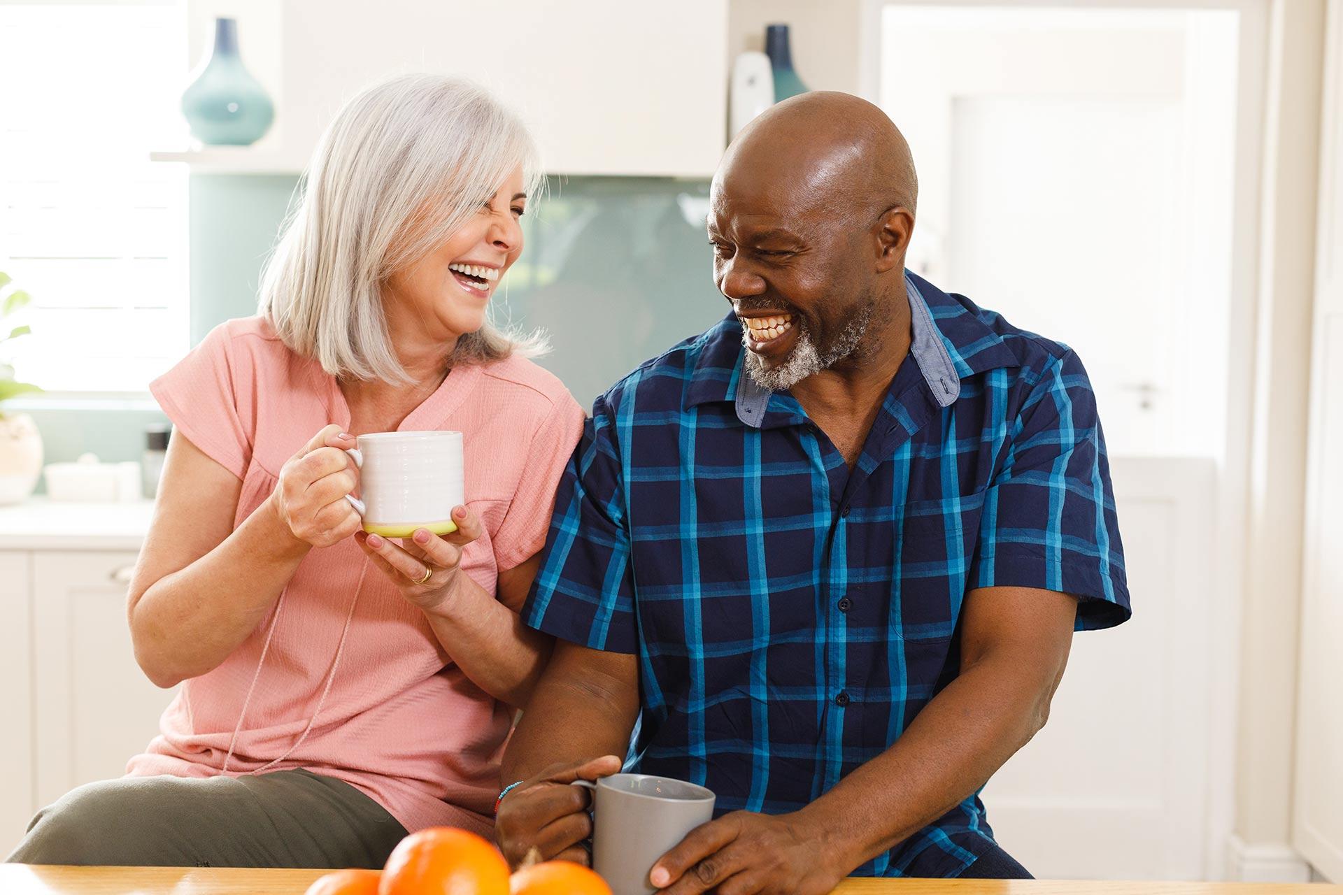 Happy Senior Diverse Couple Drinking Coffee in Kitchen